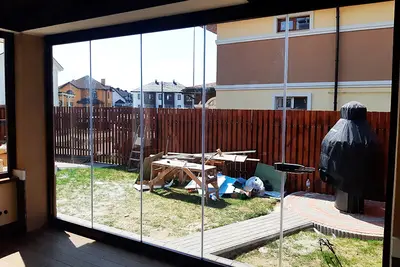 Скління кутової тераси з видом на паркан