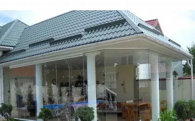 Засклена веранда з білими колонами під черепицею