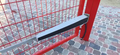 Лінійний привід на червоних ґратчастих воротах