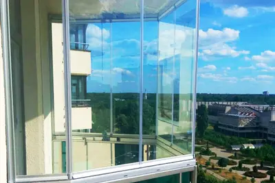 Скління балкона з видом на парк і багатоповерхівки