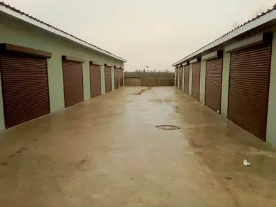 Ряд гаражів із коричневими ролетами в проїзді