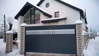 Темно-сіра ролета на в’їзді в гараж узимку