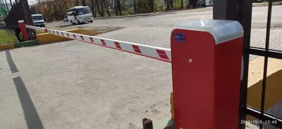 Червоно-білий шлагбаум із піднятою стрілою на в’їзді