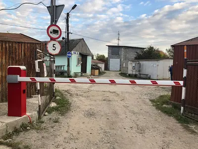 Шлагбаум зі знаком обмеження швидкості на в’їзді у двір