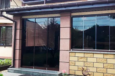 Тераса з панорамним склінням і кам’яним цоколем