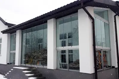 Веранда з великими вікнами й білими колонами