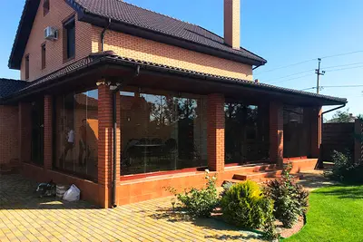 Засклена тераса цегляного будинку під черепицею