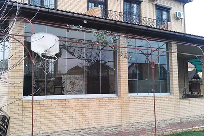 Безрамне скління тераси на цегляному фасаді