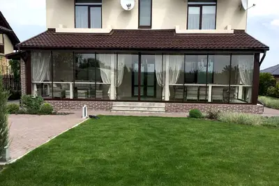 Скління тераси з великим газоном перед будинком