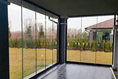 Скління тераси з колонами й видом на поле