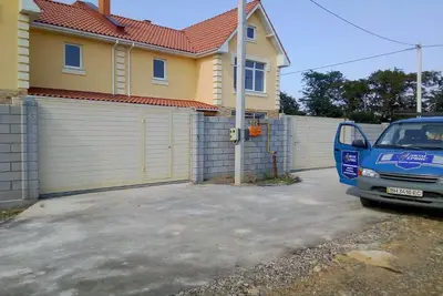 Ворота й хвіртка у дворі жовтого будинку