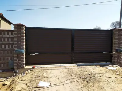 Коричневі відкатні ворота на етапі монтажу