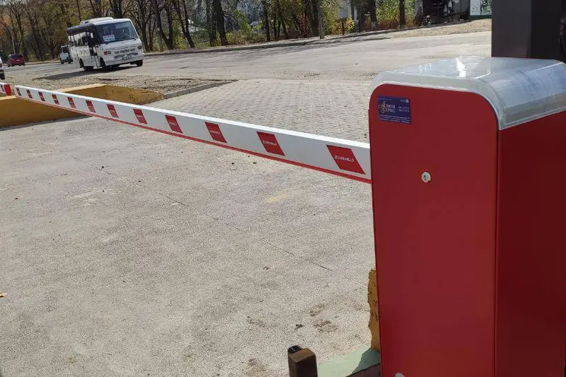 Автоматичний шлагбаум на прохідній підприємства, поруч стоять автомобілі
